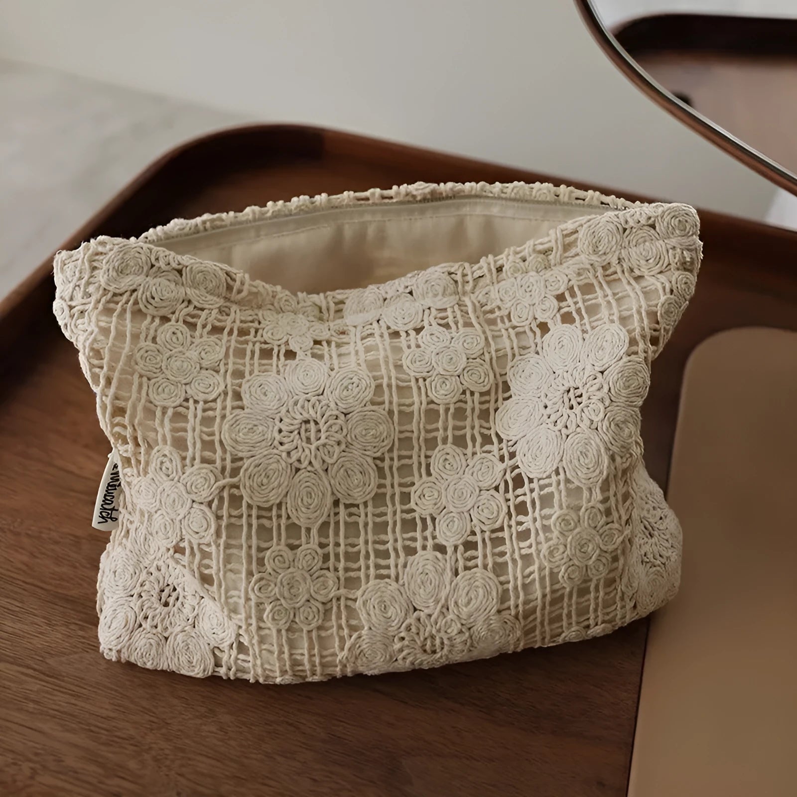 Handmade corduroy cosmetic bag with crochet flowers, ethnic embroidery, and a rope handle.