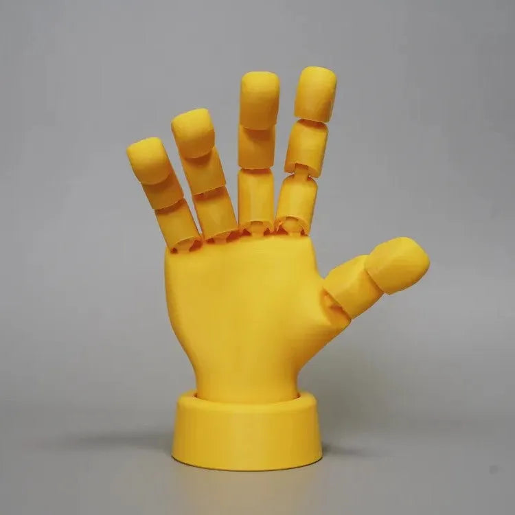 Yellow PLA hand ornament figurine with movable joint on a display surface.