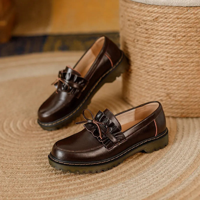 Women's black leather shoes with a chunky heel and round toe, showing the low-top design and cowhide upper.