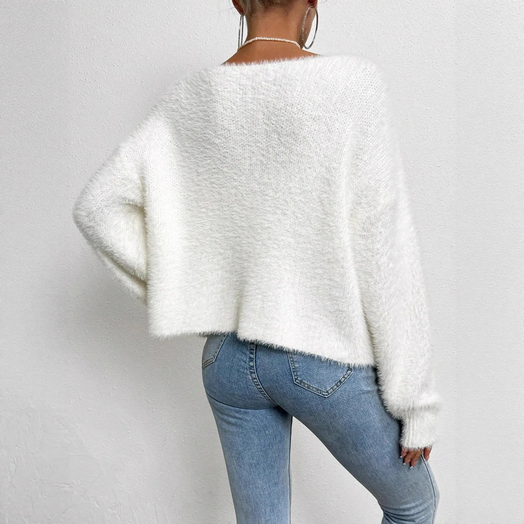 Women's white V-neck cardigan sweater made from polyester fabric.