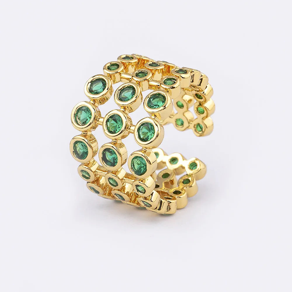 Copper ring with gold plating and green zircon stones in a wide exaggerated band.