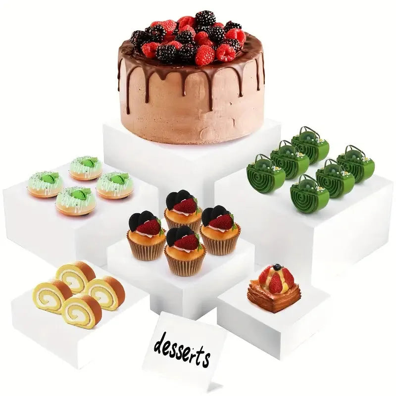 Set of six white plastic cube display stands arranged on a wooden tabletop.