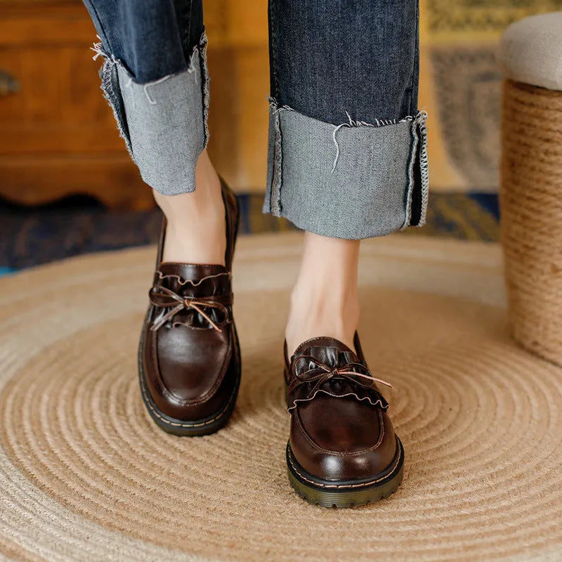 Women's black leather shoes with a chunky heel and round toe, showing the low-top design and cowhide upper.