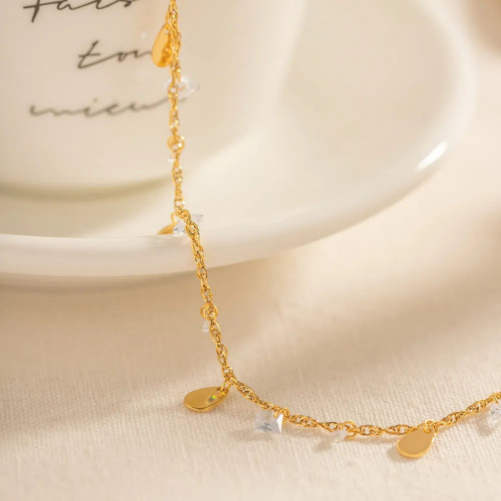 Women's stainless steel anklet with a geometric water drop pendant and a tassel detail.