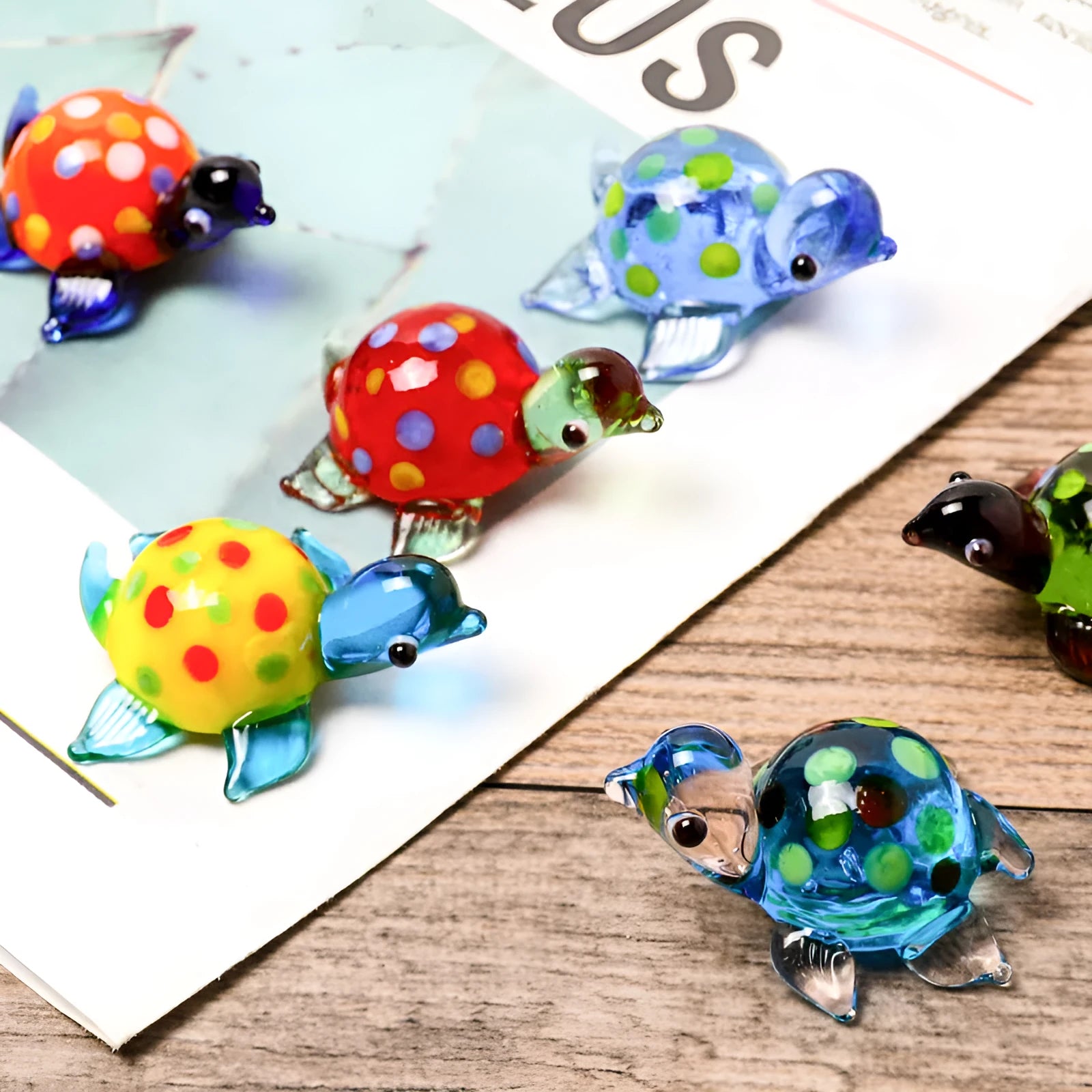 Glass geometric turtle ornament in blue head with blue shell colour variation on wooden desktop