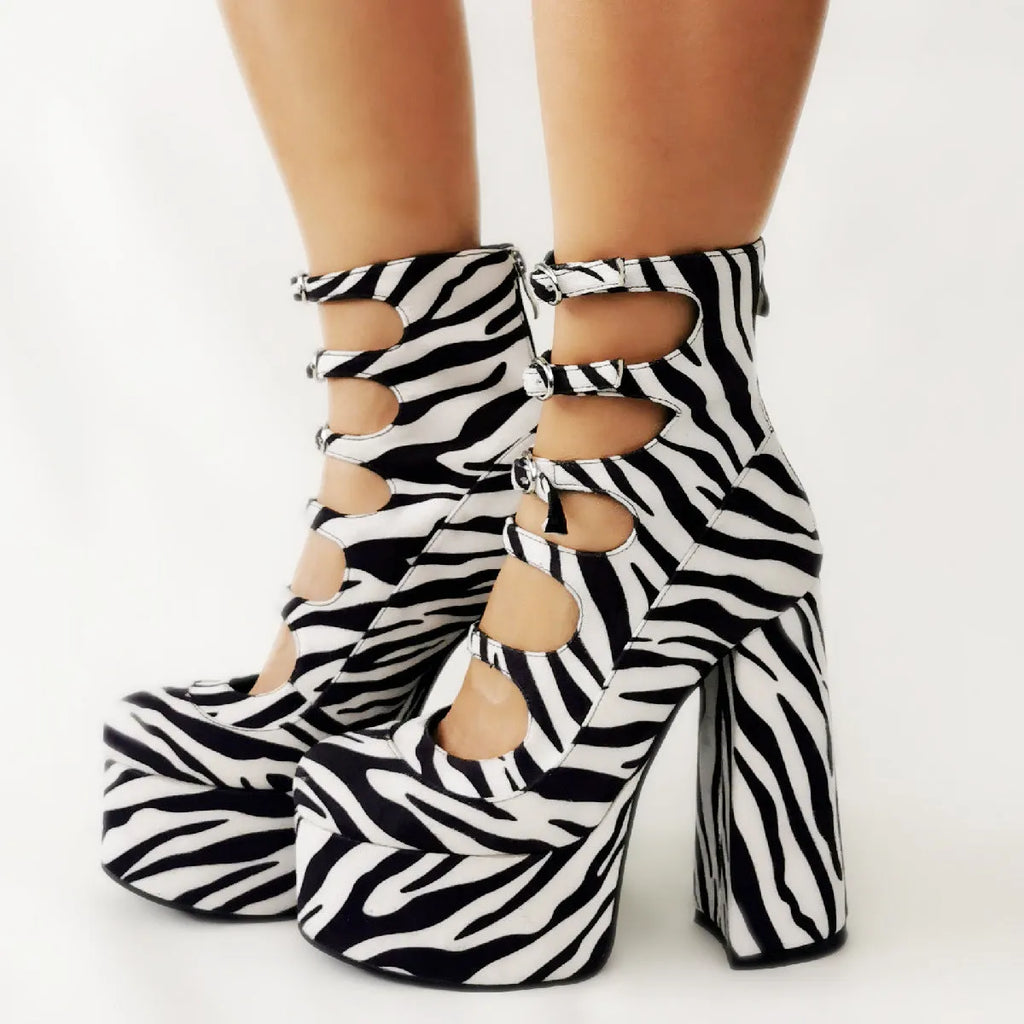 Women's black patent leather platform high heel boot with a serpentine strap and buckle closure.