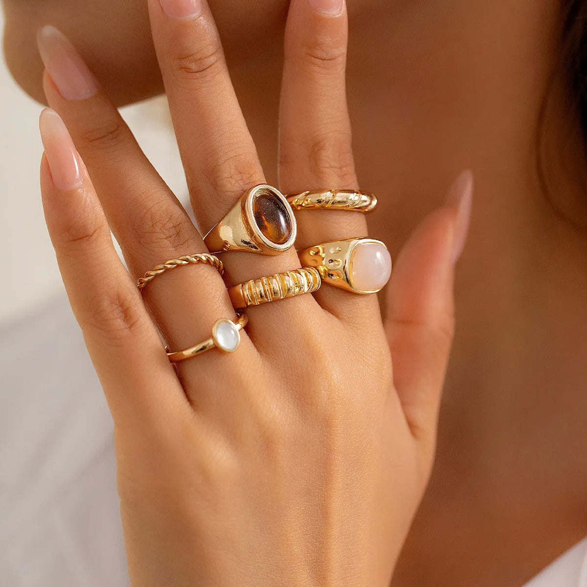 Six geometric alloy rings with electroplated light gold finish displayed as a jewellery set