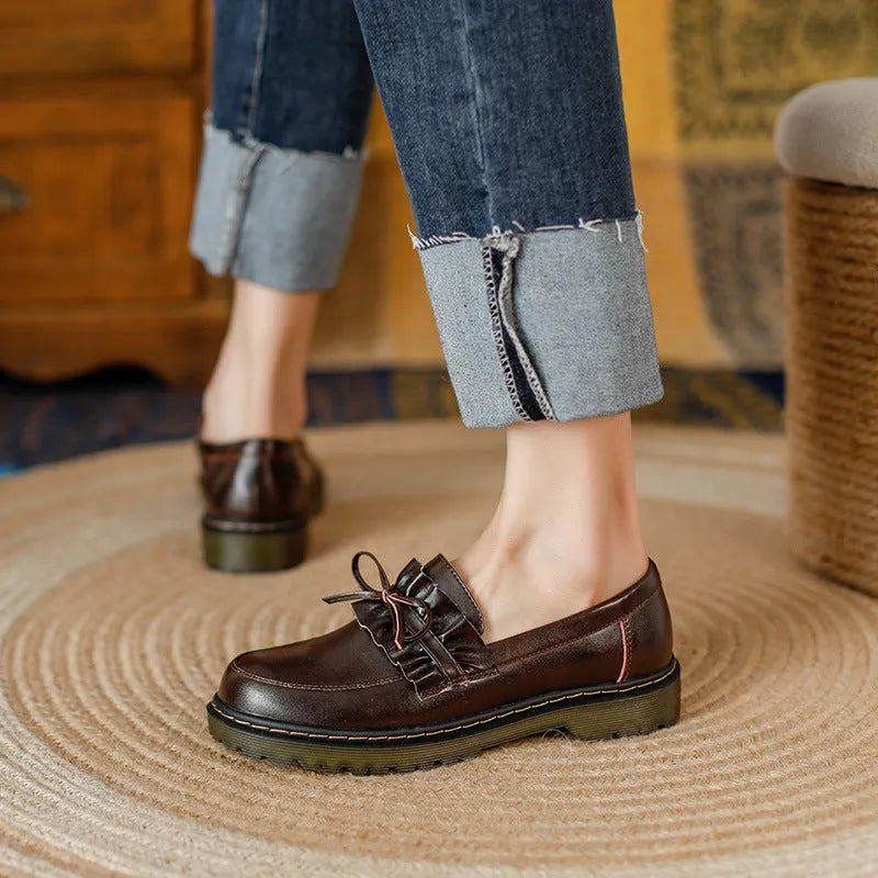 Women's black leather shoes with a chunky heel and round toe, showing the low-top design and cowhide upper.