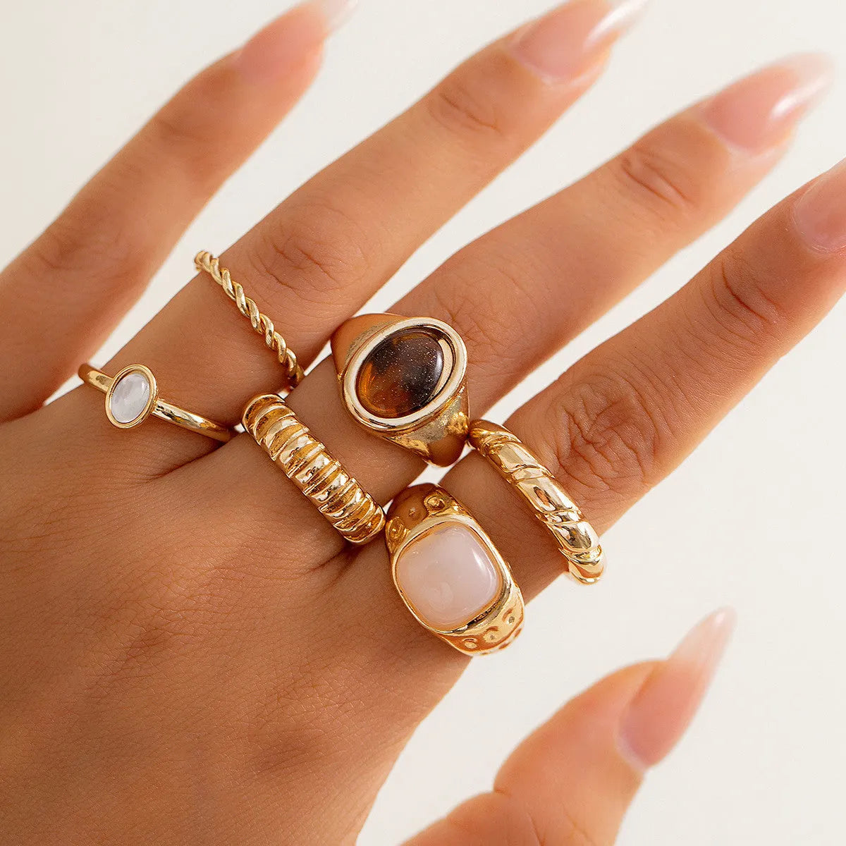 Six geometric alloy rings with electroplated light gold finish displayed as a jewellery set