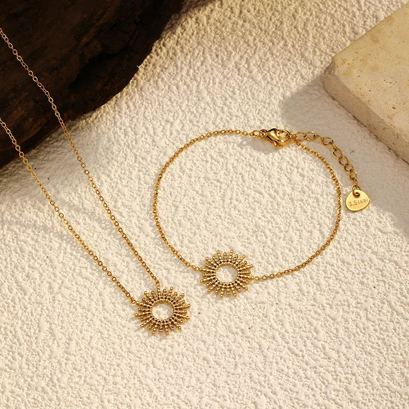 Gold tone geometric jewellery set with sun motif including necklace and bracelet for women
