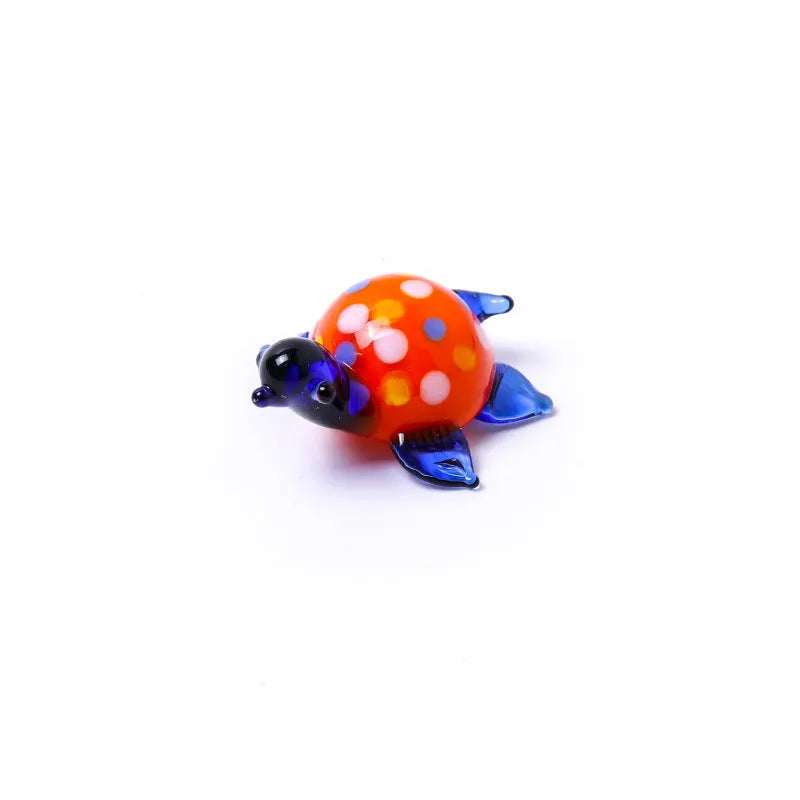Glass geometric turtle ornament in blue head with blue shell colour variation on wooden desktop