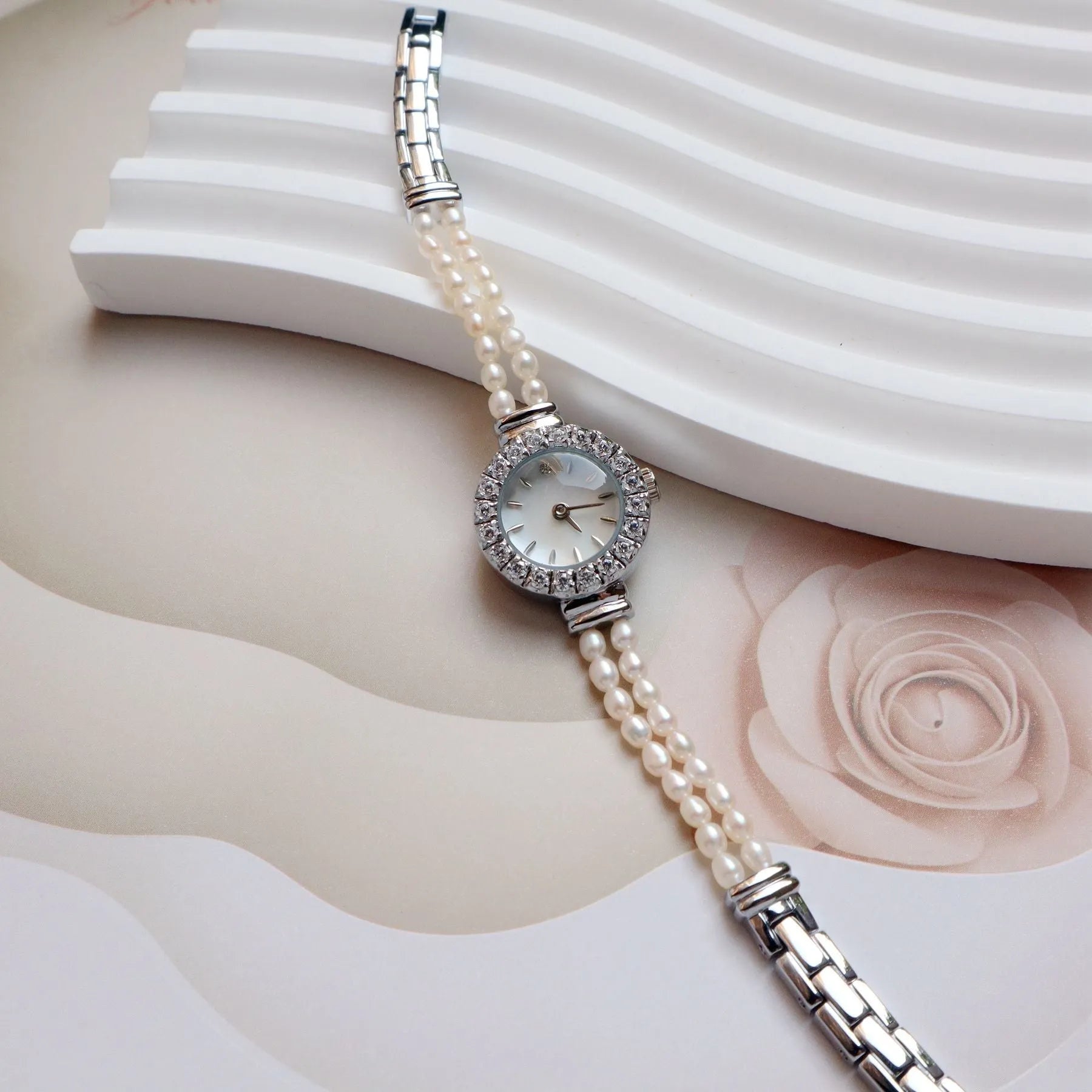 Women's light gold freshwater pearl bracelet watch with round dial on wrist