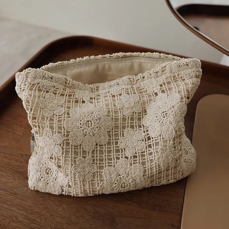 Handmade corduroy cosmetic bag with crochet flowers, ethnic embroidery, and a rope handle.