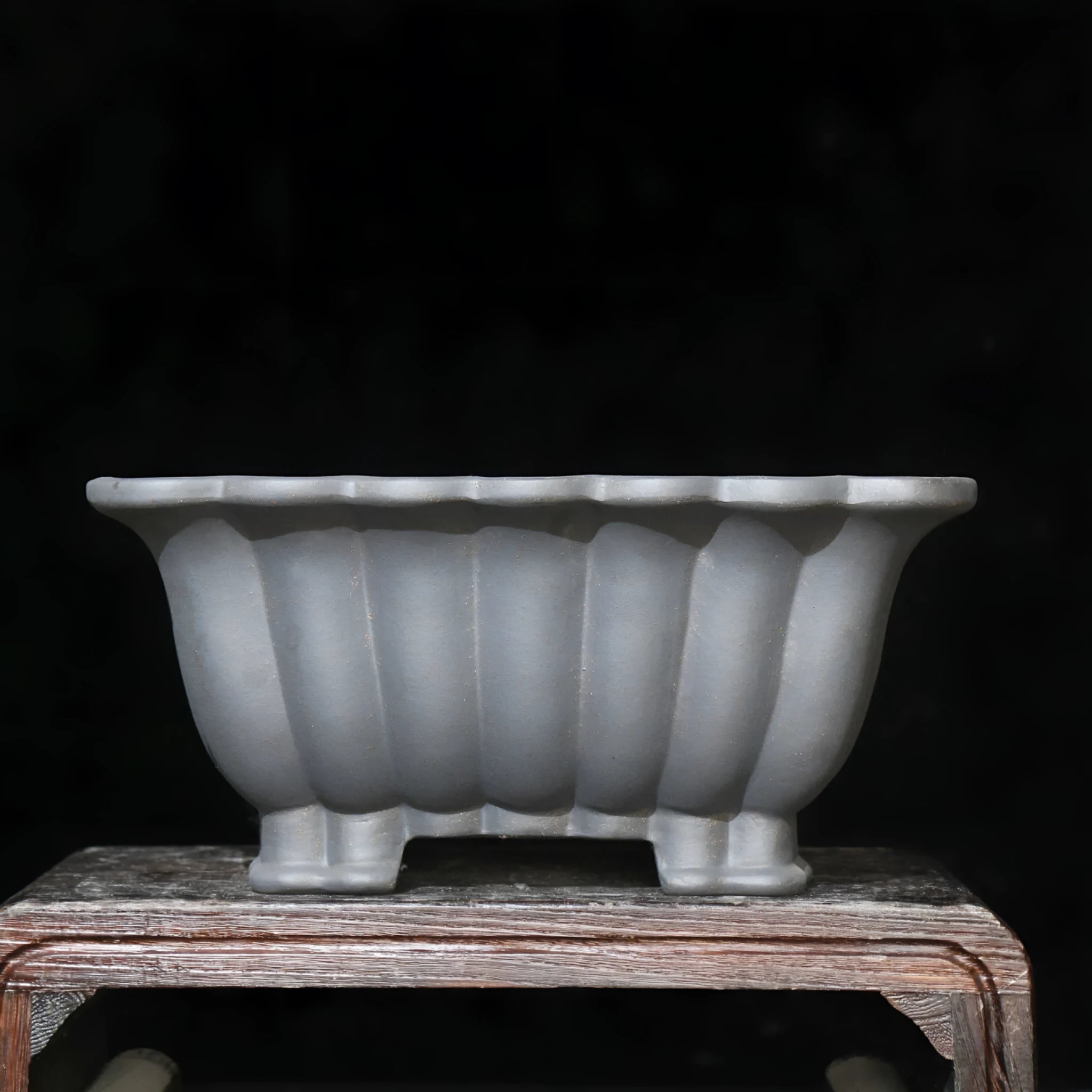 Square purple sand ceramic bonsai pot with warp device on a desktop.