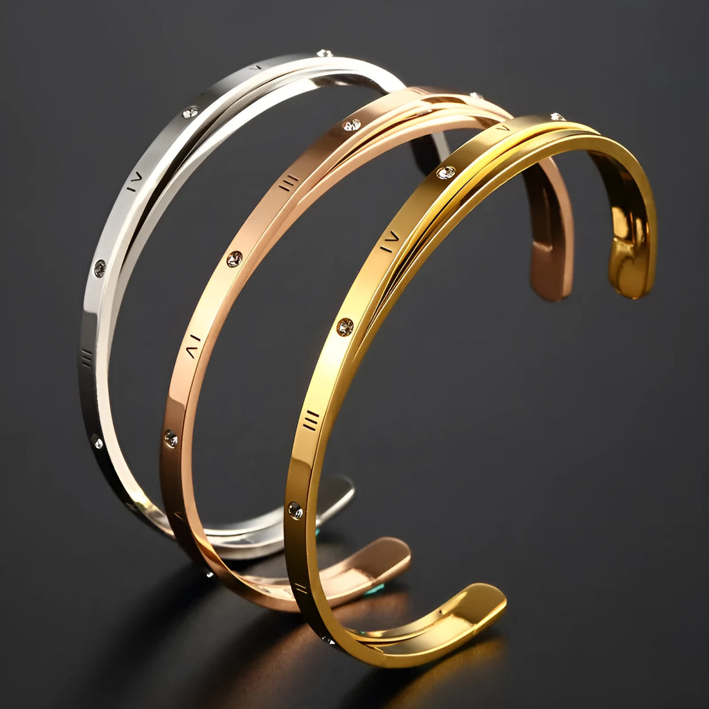 Open-ended stainless steel bracelet for women with inlaid zircon stones, shown in gold colour on a wrist.