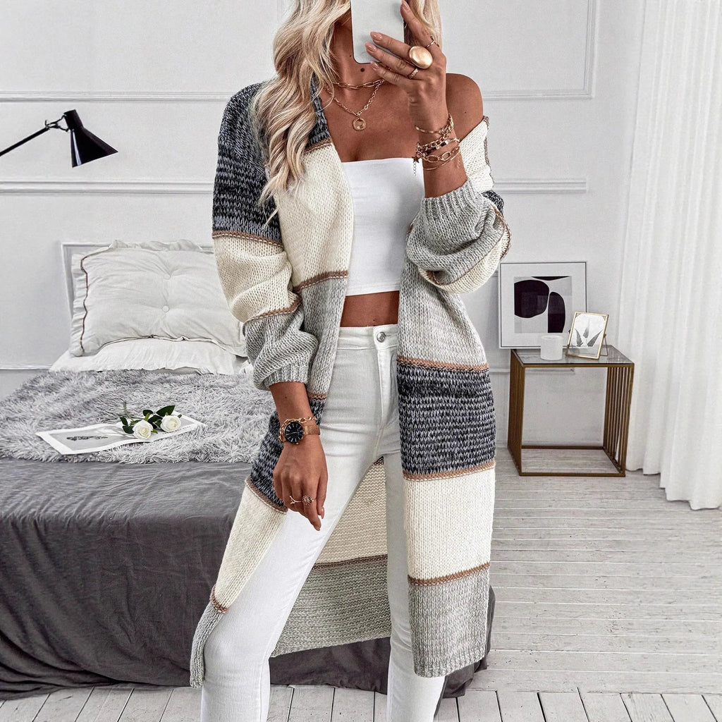Grey striped women's long sleeve knitted cardigan on a hanger, showing loose fit.