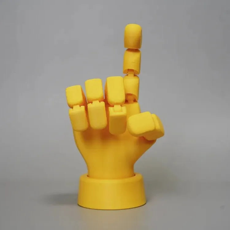 Yellow PLA hand ornament figurine with movable joint on a display surface.