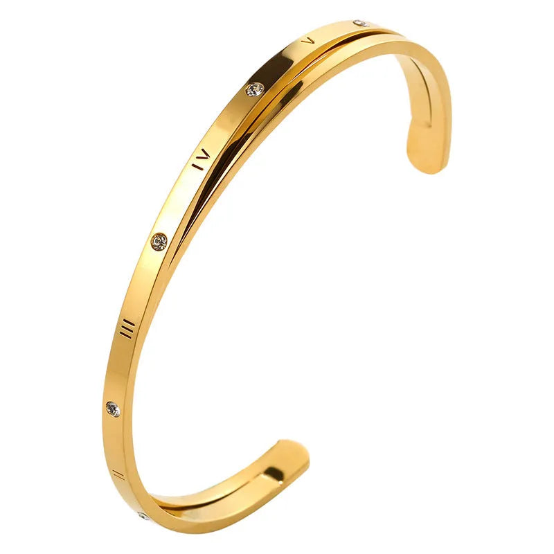 Open-ended stainless steel bracelet for women with inlaid zircon stones, shown in gold colour on a wrist.