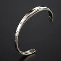 Open-ended stainless steel bracelet for women with inlaid zircon stones, shown in gold colour on a wrist.