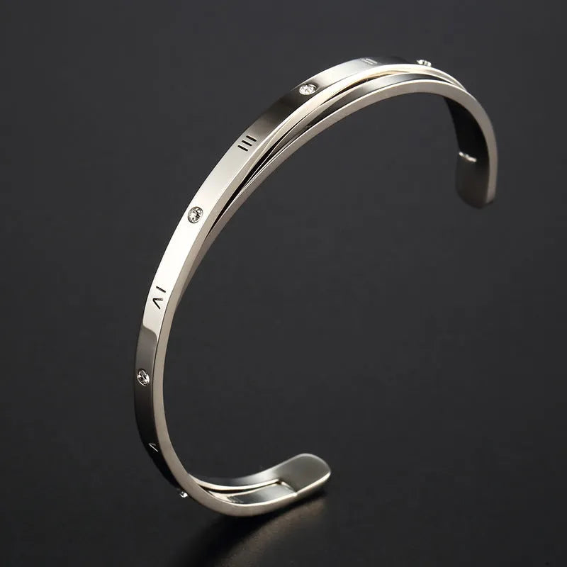 Open-ended stainless steel bracelet for women with inlaid zircon stones, shown in gold colour on a wrist.