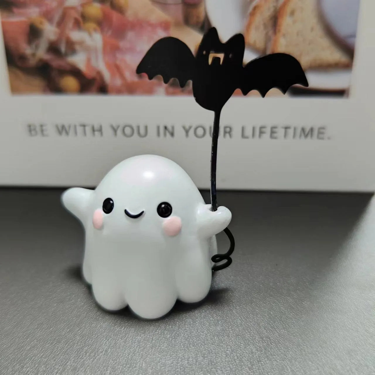 Miniature resin statue of a ghost walking a dog and holding a bat, a 4cm tall Halloween decoration.