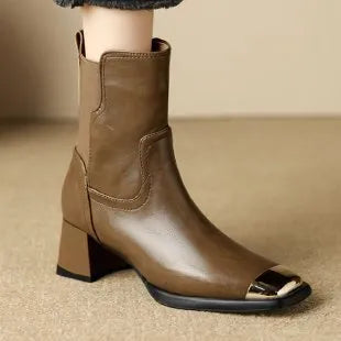 Brown cowhide leather women's Martin boots with side zipper and high heel on a white background.