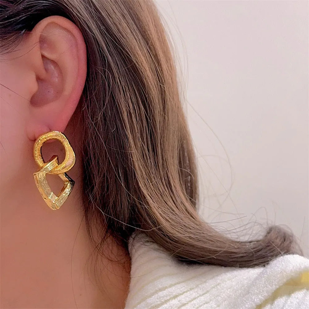 Gold and silver geometric pendant earrings with a 3.4cm retro design