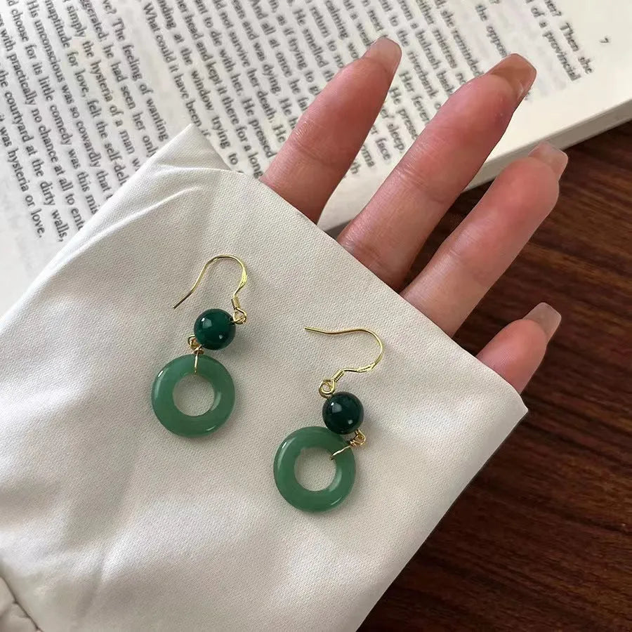 Green geometric peace buckle earrings with 14K gold plating on a zinc alloy base.