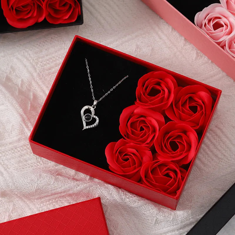 Korean style gift box open to show six red soap flowers, with a handbag beside it.