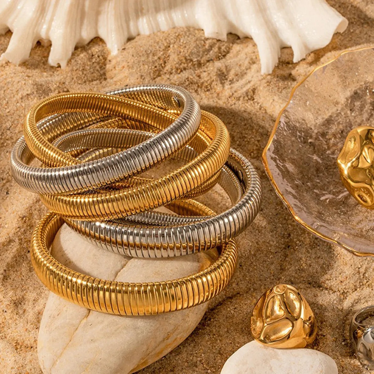 Women's gold titanium steel bracelet with exaggerated vertical stripe ring pattern and elastic band.