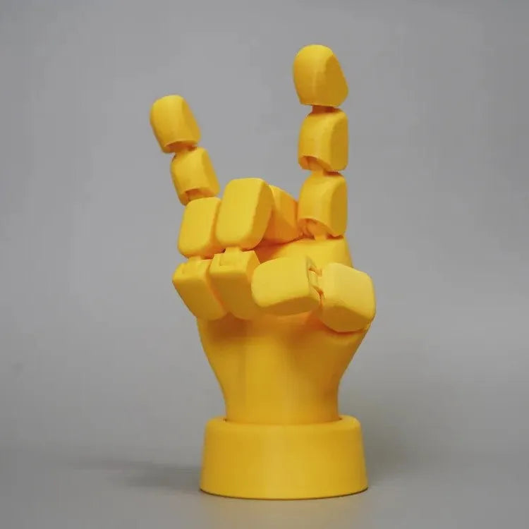 Yellow PLA hand ornament figurine with movable joint on a display surface.