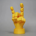 Yellow PLA hand ornament figurine with movable joint on a display surface.