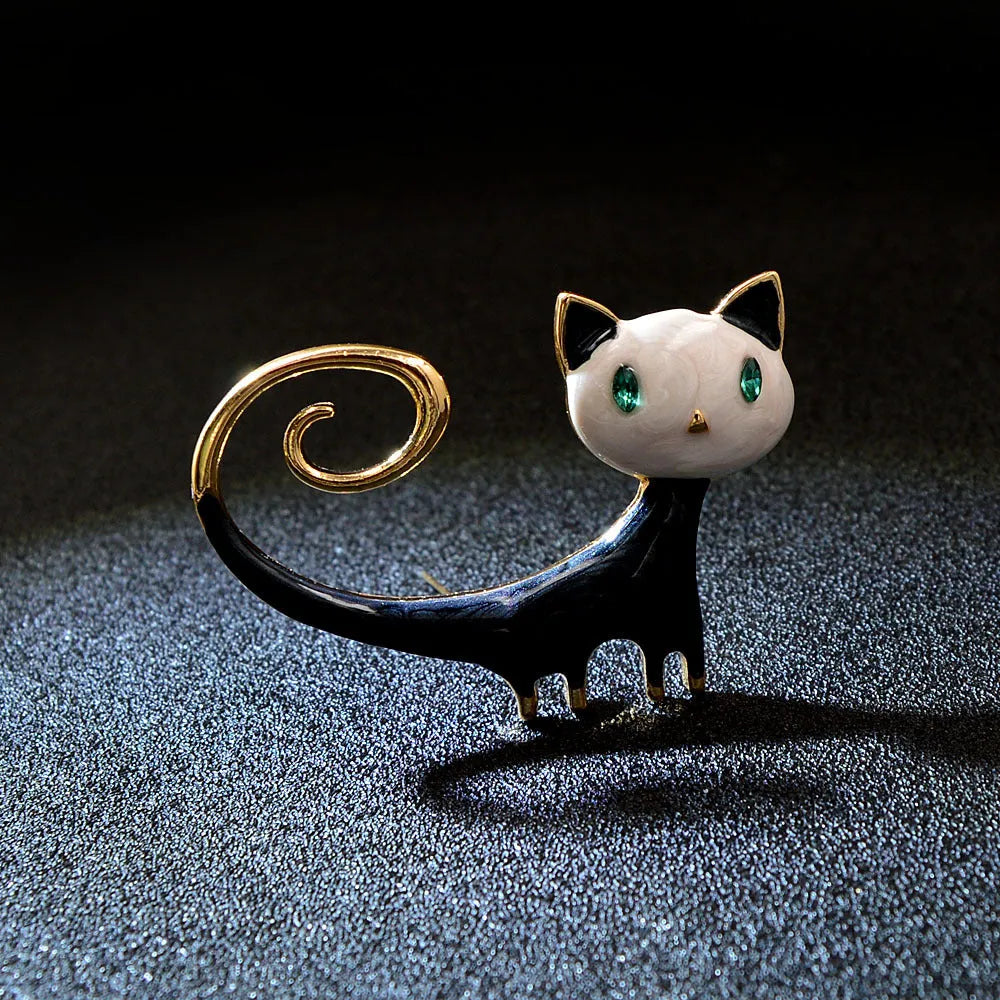 Close-up of a hand-painted tail-up kitten brooch in alloy metal, on a white background.