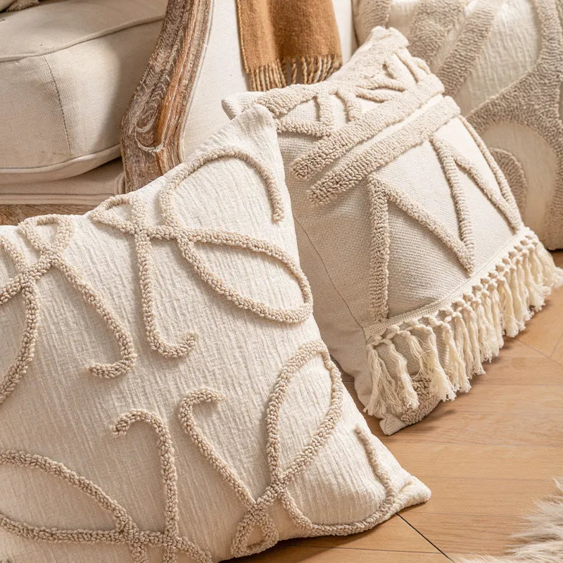 Knitted tassel pillow cover in striped pattern on a sofa.