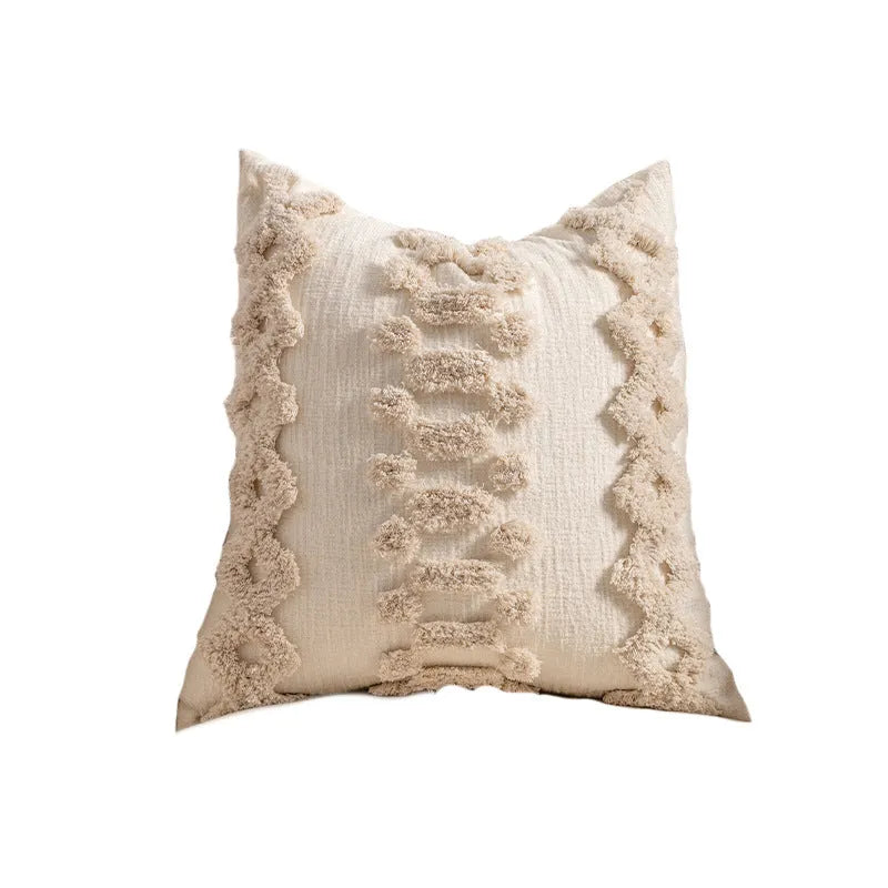 Knitted tassel pillow cover in striped pattern on a sofa.