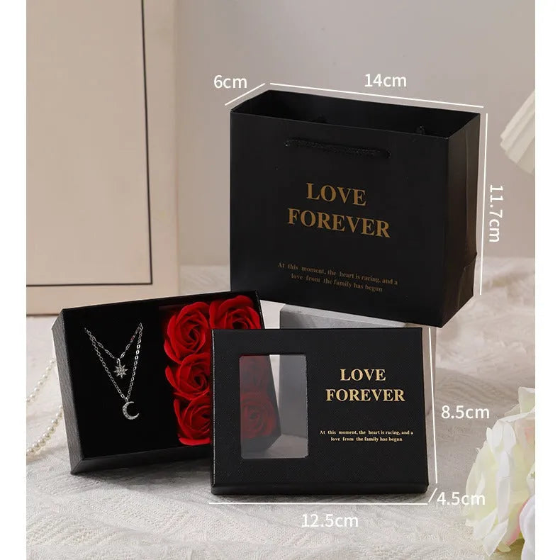 Korean style gift box open to show six red soap flowers, with a handbag beside it.