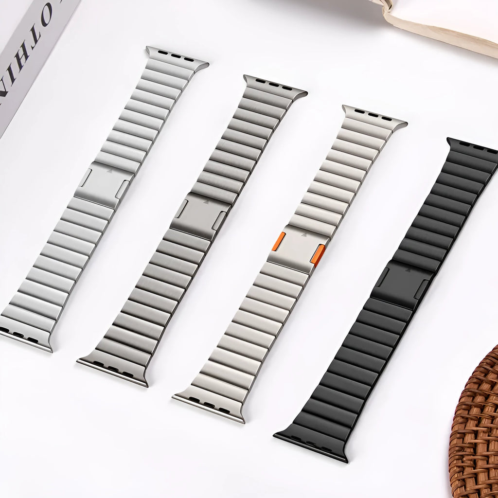 Stainless steel Apple Watch band with magnetic clasp in silver colour on a table.