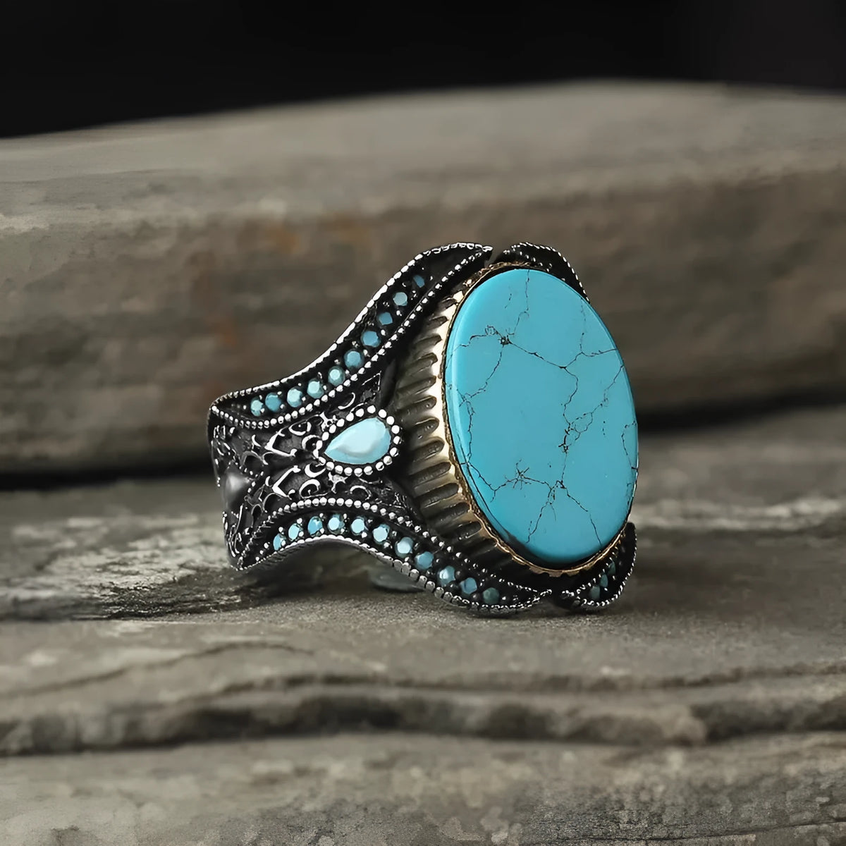 Men's antique silver alloy ring with a round band and a turquoise blue centrepiece on a hand.