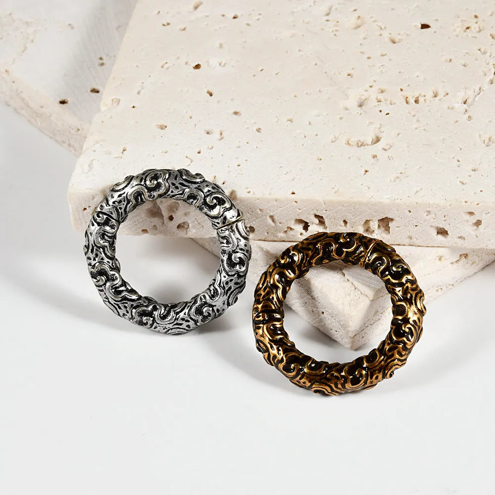 A pair of stainless steel fashion earrings with an intricate totem pattern design in a silver-toned finish.