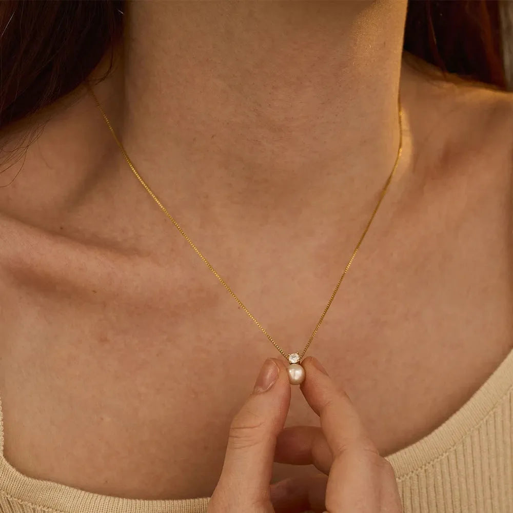 Gold and steel colour women's necklace with imitation pearl and zircon pendant on a stainless steel box chain.