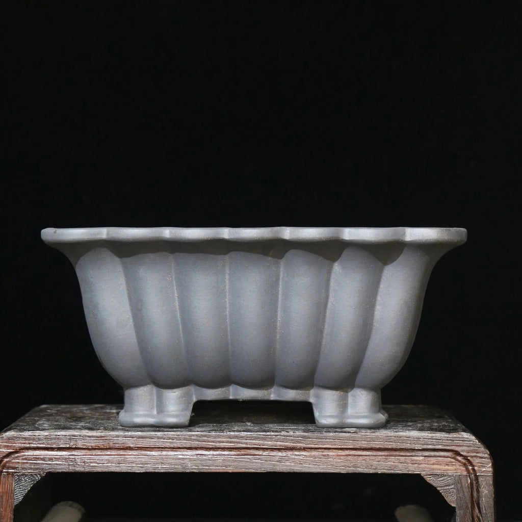 Square purple sand ceramic bonsai pot with warp device on a desktop.