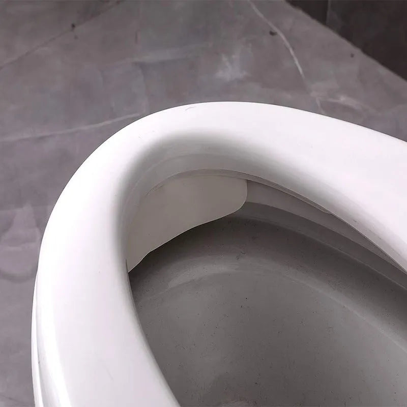 White PVC toilet urine splash guard board for boys potty training on a toilet seat.