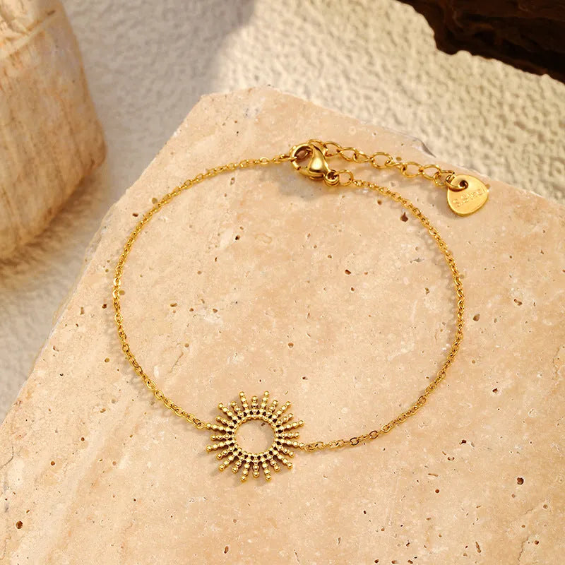 Gold tone geometric jewellery set with sun motif including necklace and bracelet for women