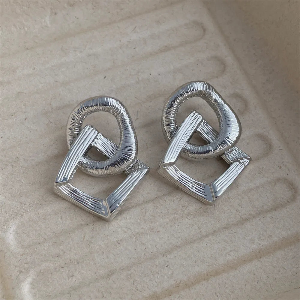 Gold and silver geometric pendant earrings with a 3.4cm retro design
