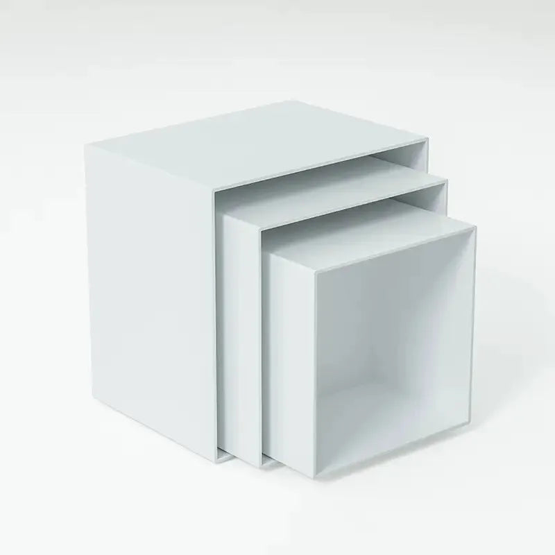 Set of six white plastic cube display stands arranged on a wooden tabletop.