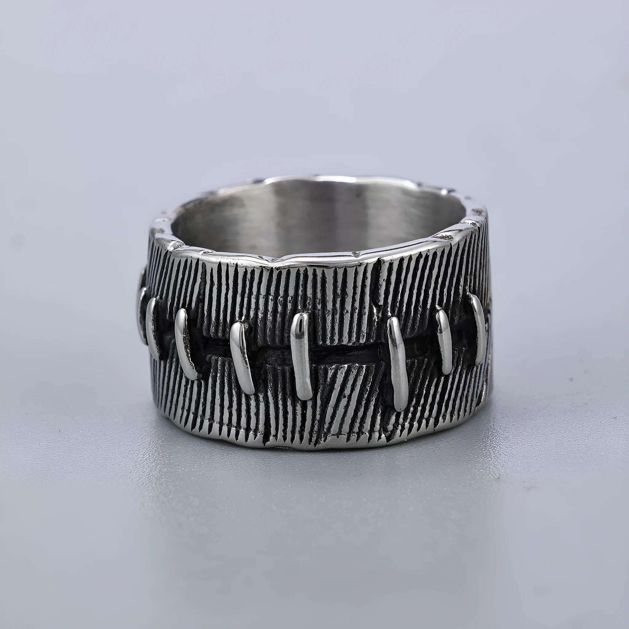 Titanium steel geometric U-shaped double ring in retro black colour, showing stitched design detail.