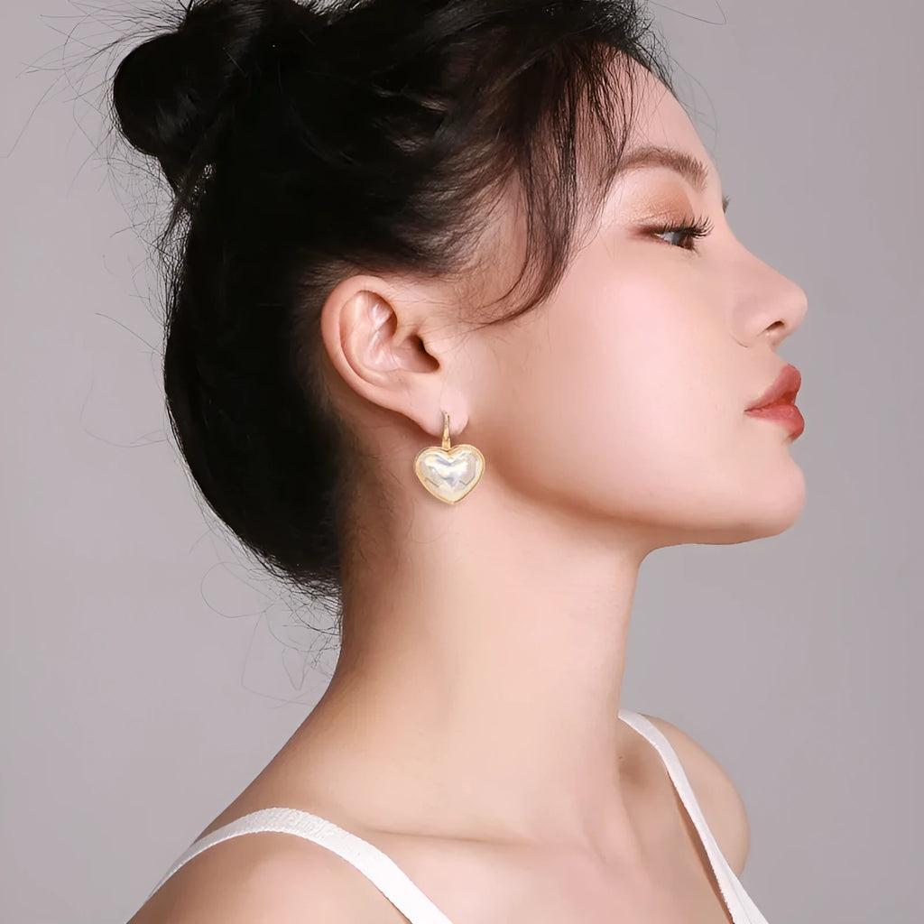 A pair of gold-coloured women's ear clips with a natural design on a white background.