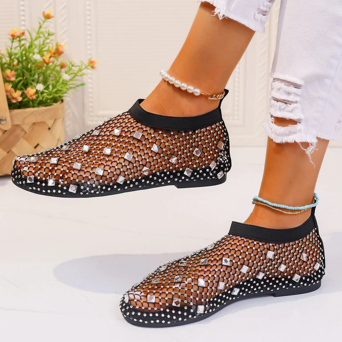 Women's flat sandals with colourful rhinestones on a mesh upper and rubber sole.