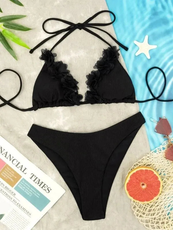 Black women's bikini set with gathered top and matching shorts laid flat.
