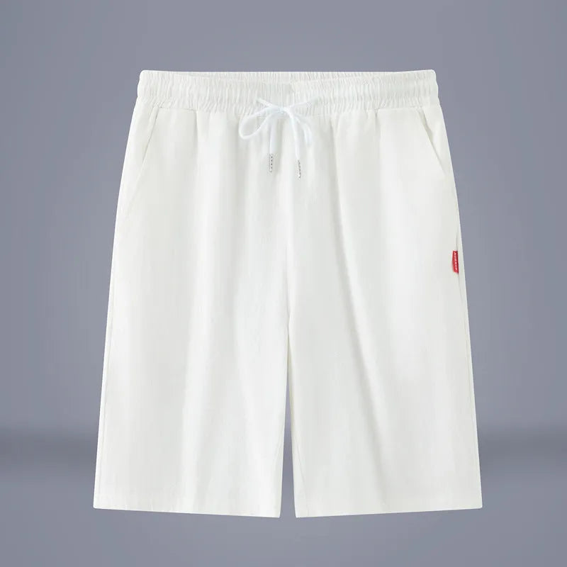Man wearing solid colour cotton linen cropped trousers with a drawstring waist in a casual setting.